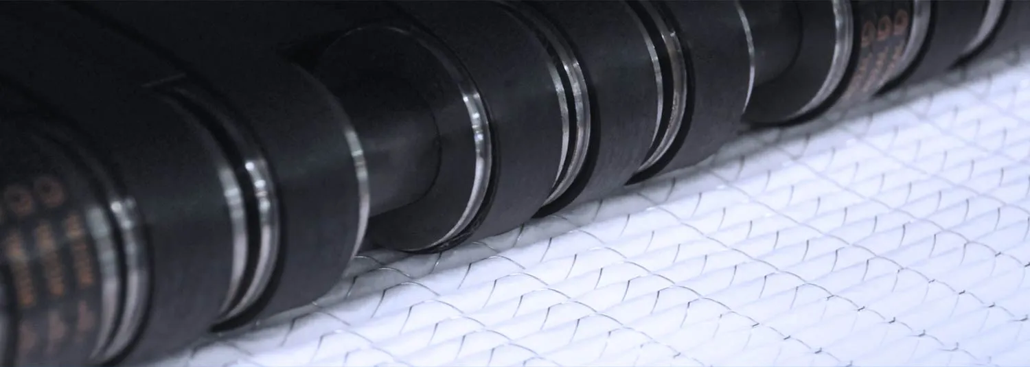 Pleated filter media with expanded metal backing running under laminator rollers
